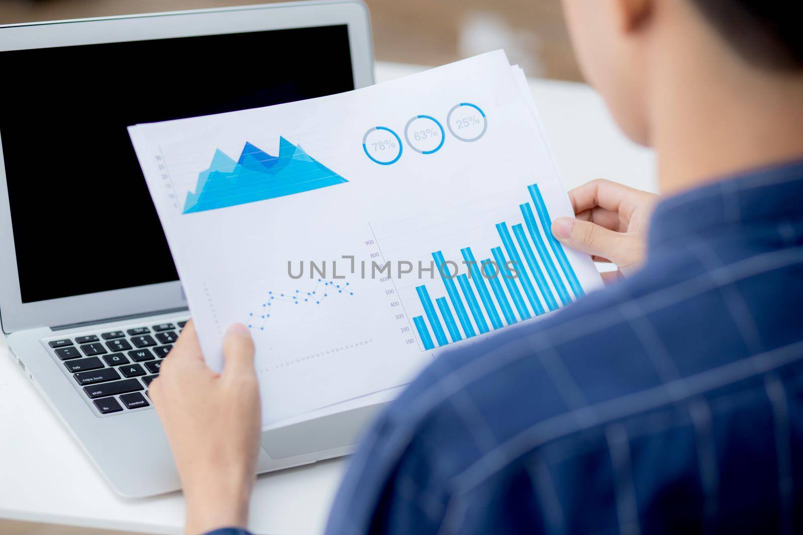 Hand of young business man looking document data graph and chart paper, marketing and investment, report of statistics profit for financial, economic and growth of finance, management and planning.