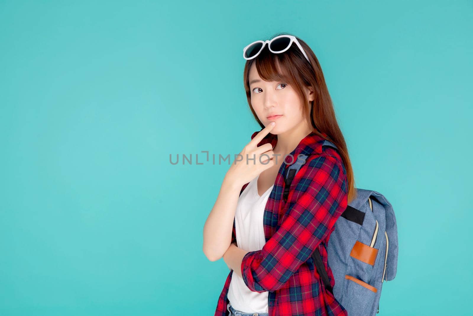 Beautiful portrait young asian woman wear sunglasses on head smile confident thinking and idea summer holiday isolated blue background, model girl fashion in vacation, travel concept.