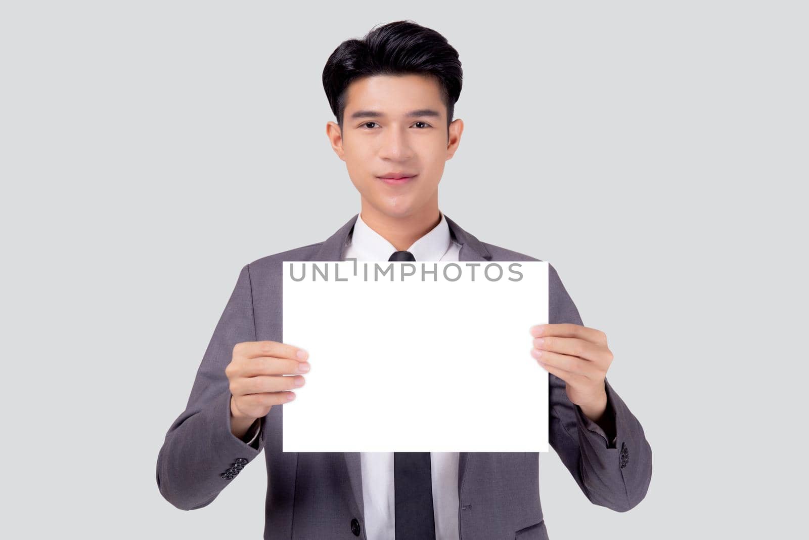 Young asian business man showing empty signboard for advertising isolated on white background, businessman confident holding billboard banner for presenting with copy space, success and achievement.