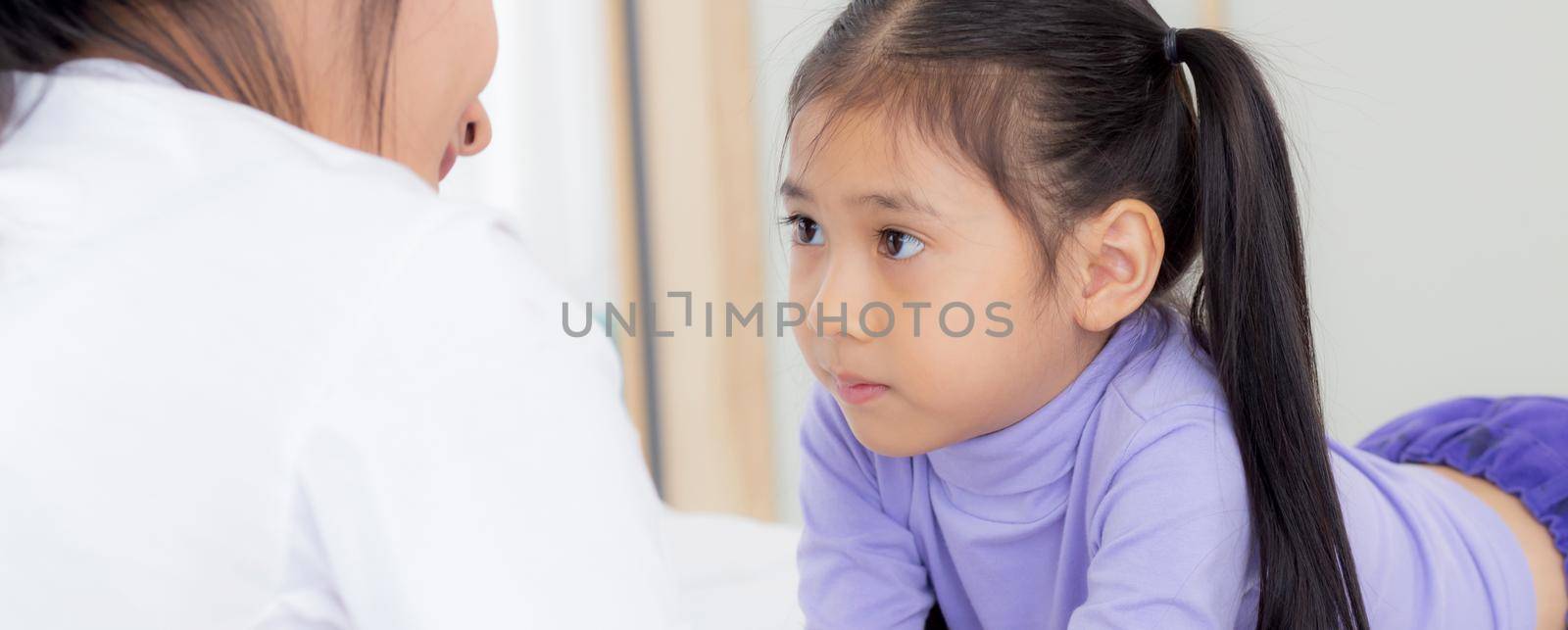 Young asian mom and daughter smiling and eye contact together with care in room, face of mother and girl looking eye with relationship and bonding, emotion and expression, family and love concept. by nnudoo