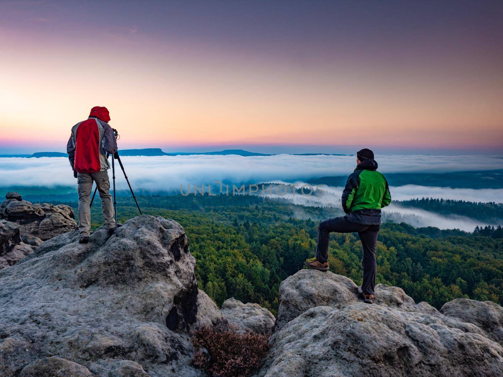 Photographer prepared to take pictures in the mountains. Fall autumn forest nature landscape. Active man enjoying hike and healthy outdoor active lifestyle.
