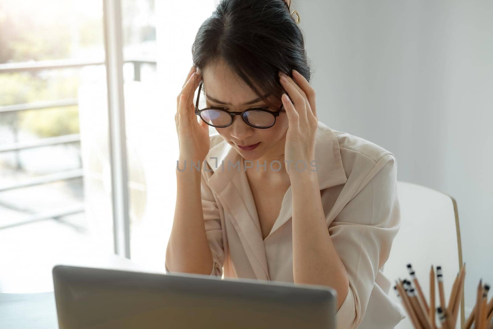 Tired asian business woman with headache from laptop computer work feeling headache at office, feeling sick at work,