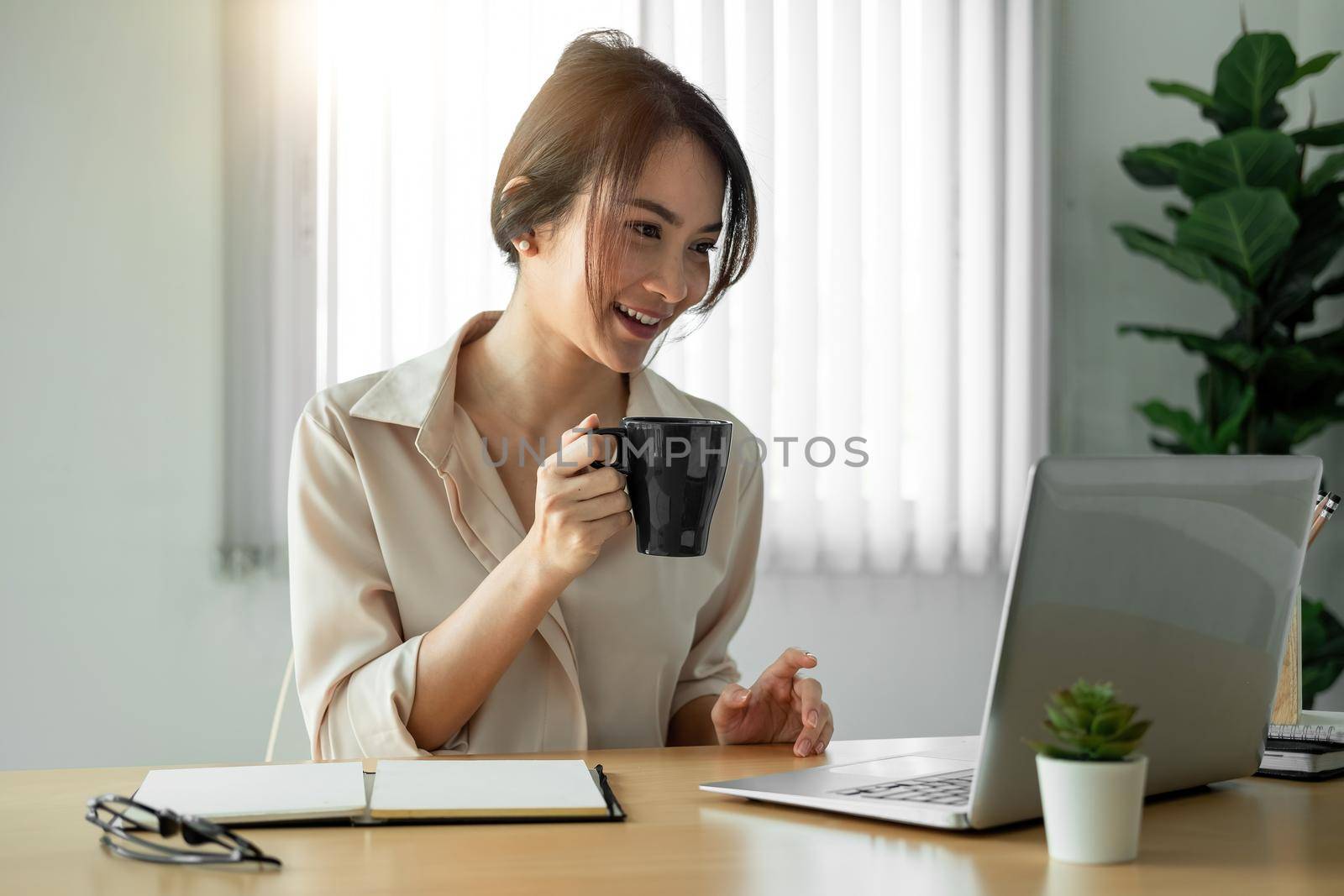 beautiful asian woman freelancer working on laptop with coffee cup in home office. by nateemee