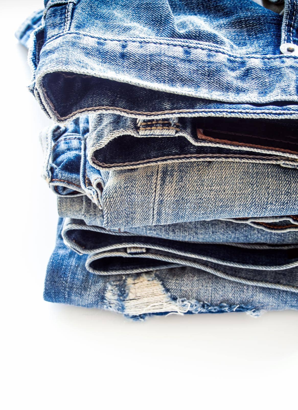 Pile of different blue jeans, fabric texture