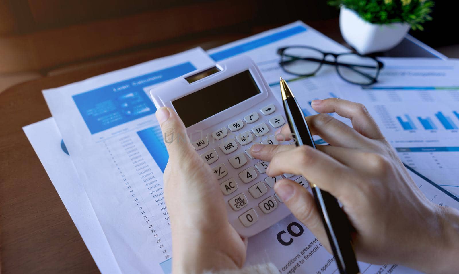 Close up businesswoman holding calculator and press on the button. business financial accounting concept. by pravinrus