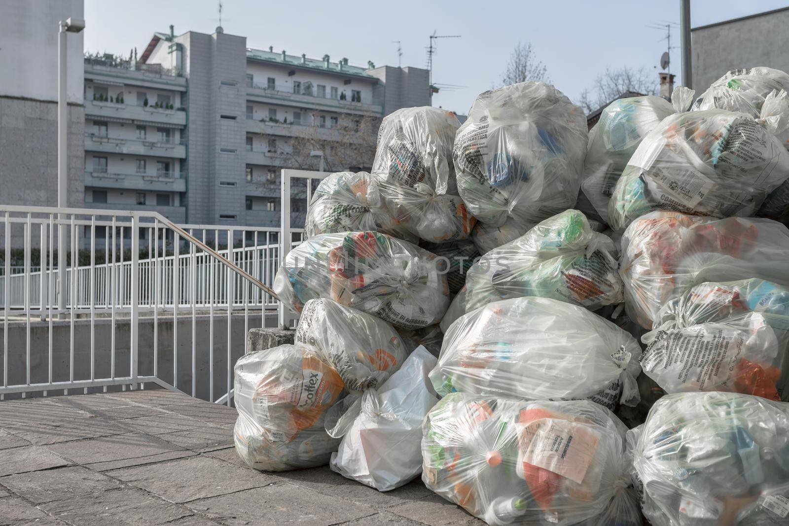 Trash bags on the sidewalk. Transparent bags for differentiated waste collection. Bergamo, ITALY - February 23, 2021.