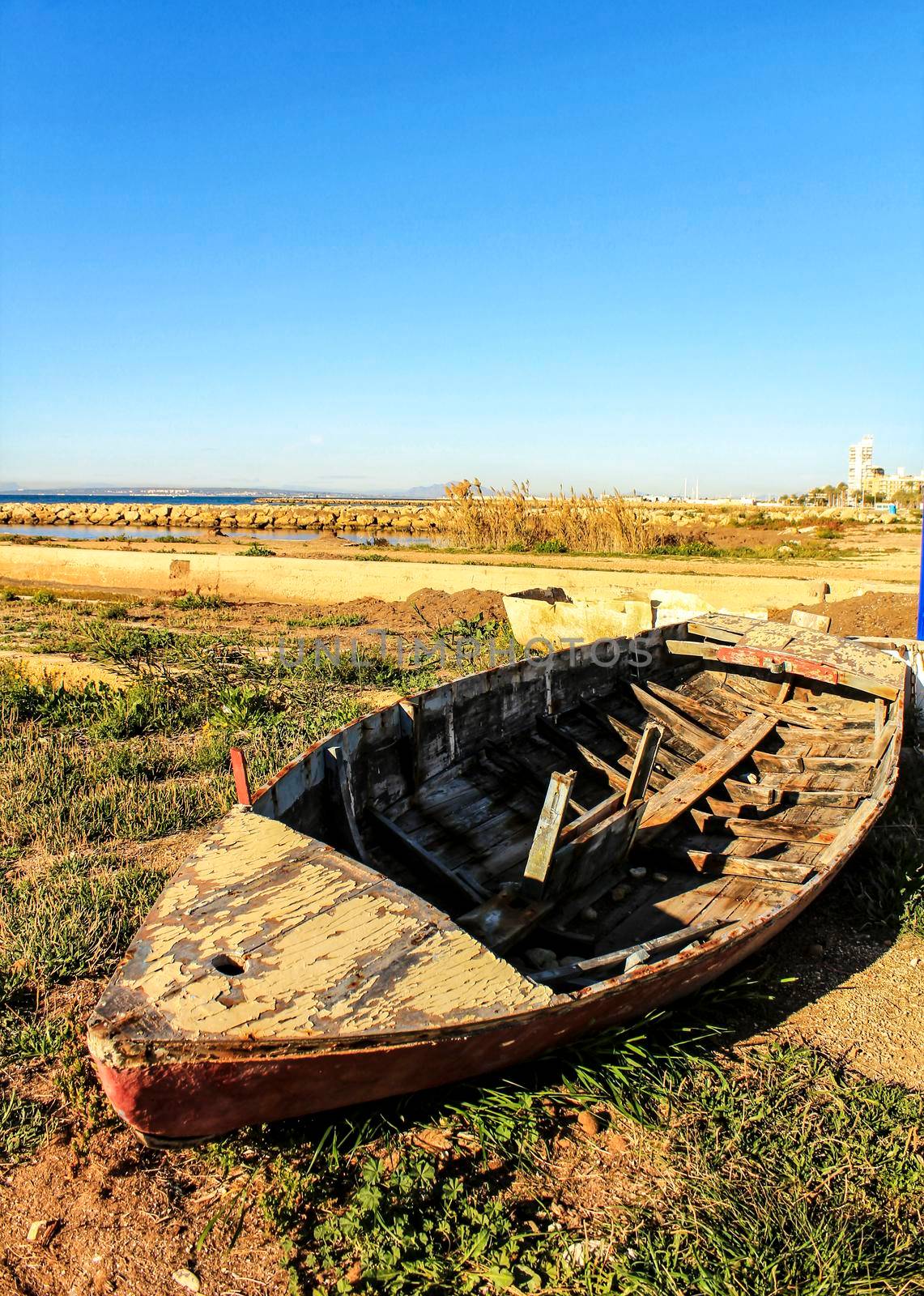 Old abandoned wooden boat on the beach in Santa Pola, Alicante, Spain