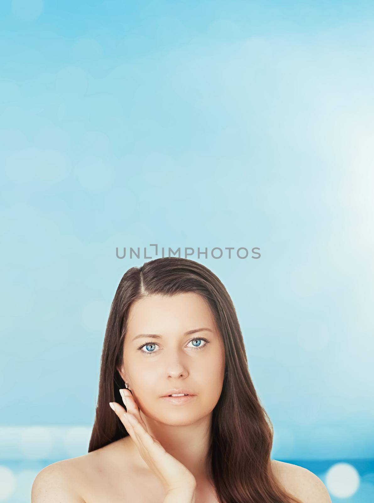 Skincare and sun protection in summer. Portrait of a beautiful young suntanned woman, blue sea and sky on background, beauty, wellness and travel concept.