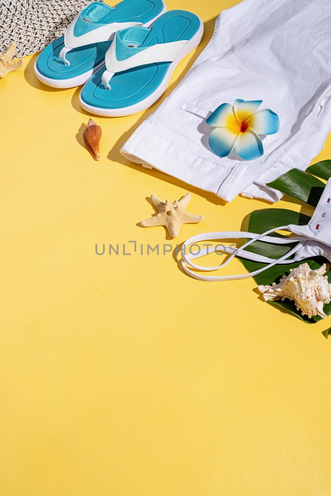 Summer and vacation concept. summer accessories with clothes, shoes, tropical leaves and flowers, flat lay