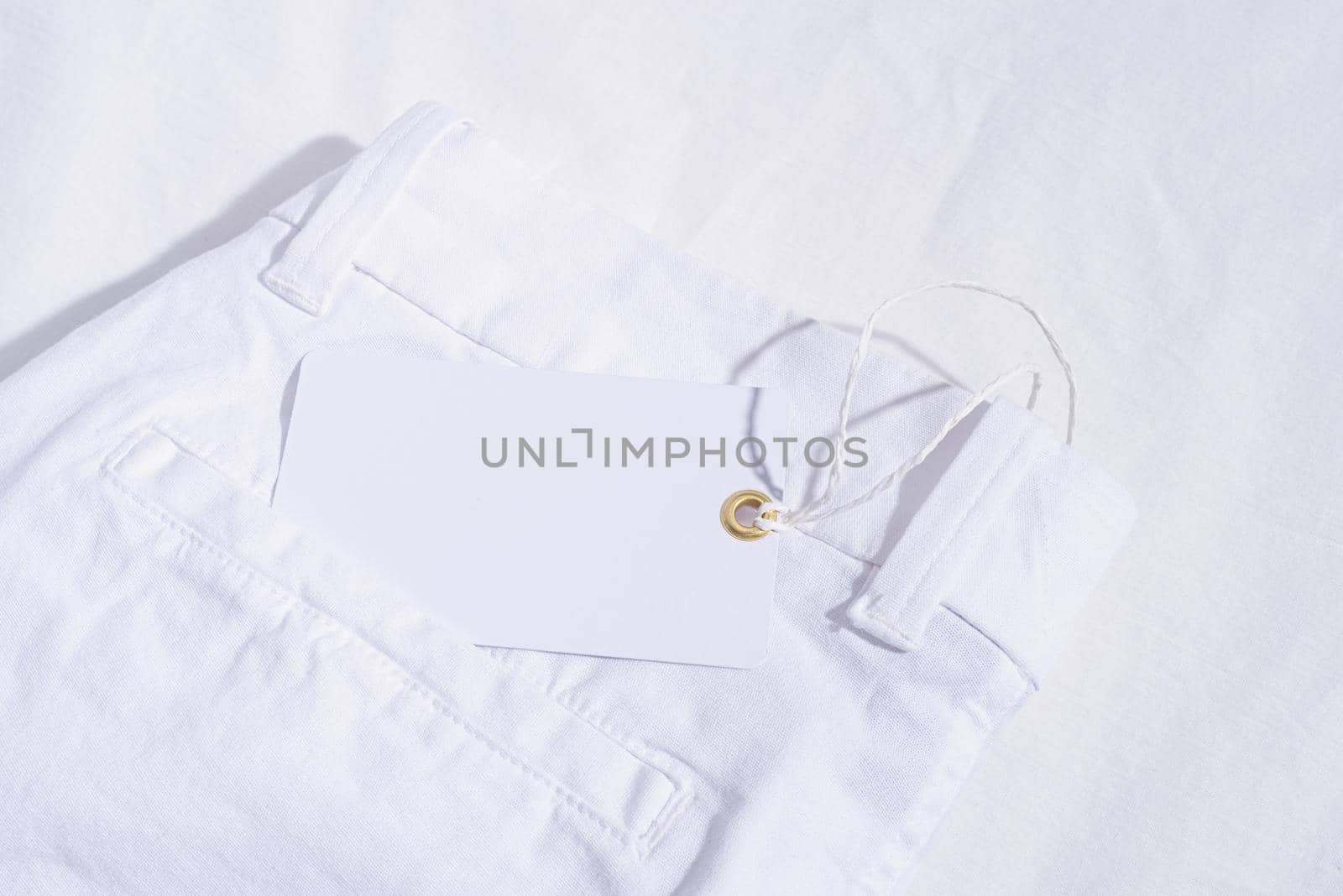 Summer and vacation concept. White summer jeanson white background with blank price tag. Mock up design