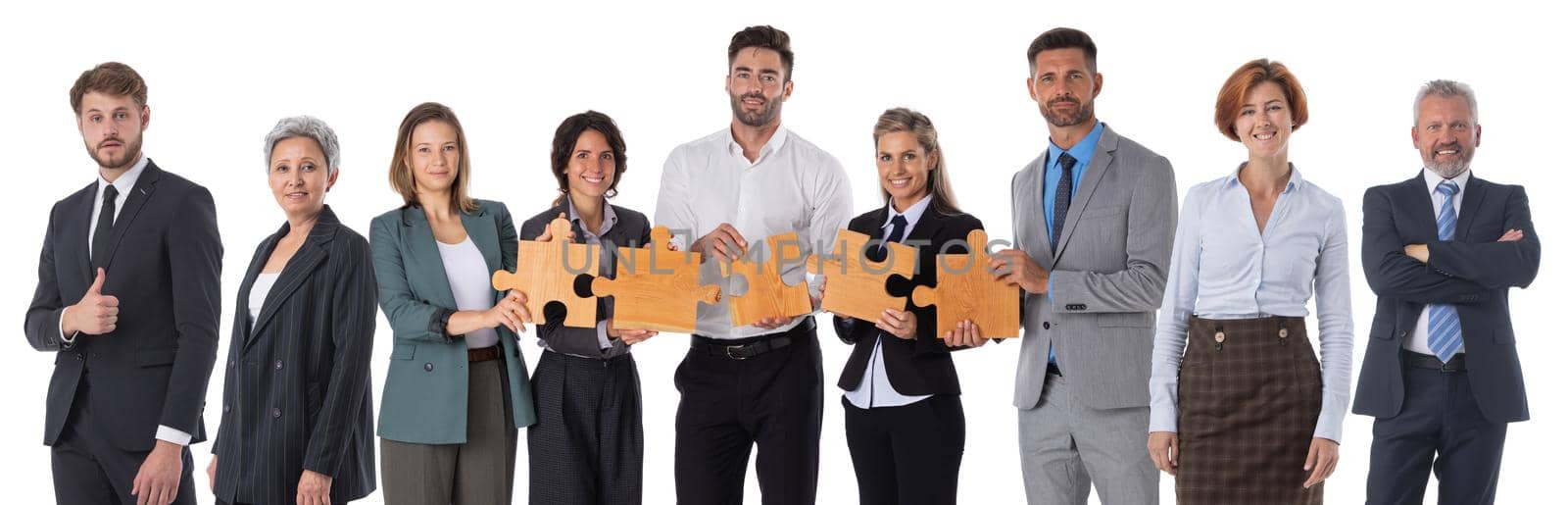Group of business people standing with pieces of a puzzle isolated on white background