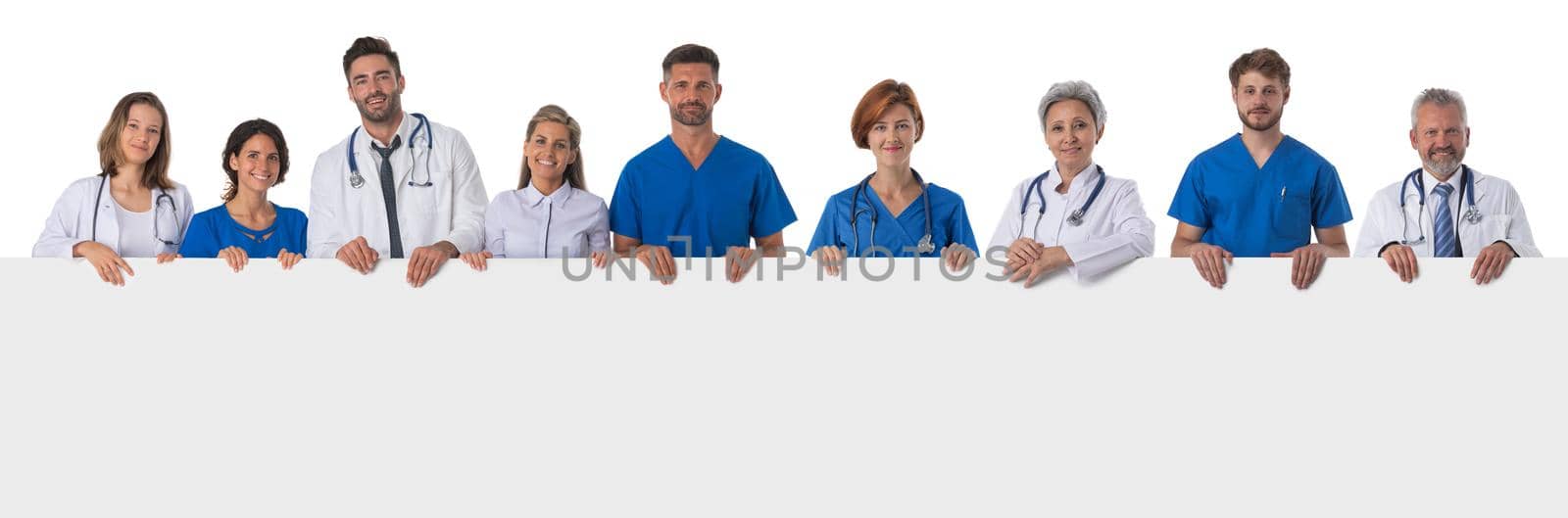 Group of doctors with blank banner isolated over a white background