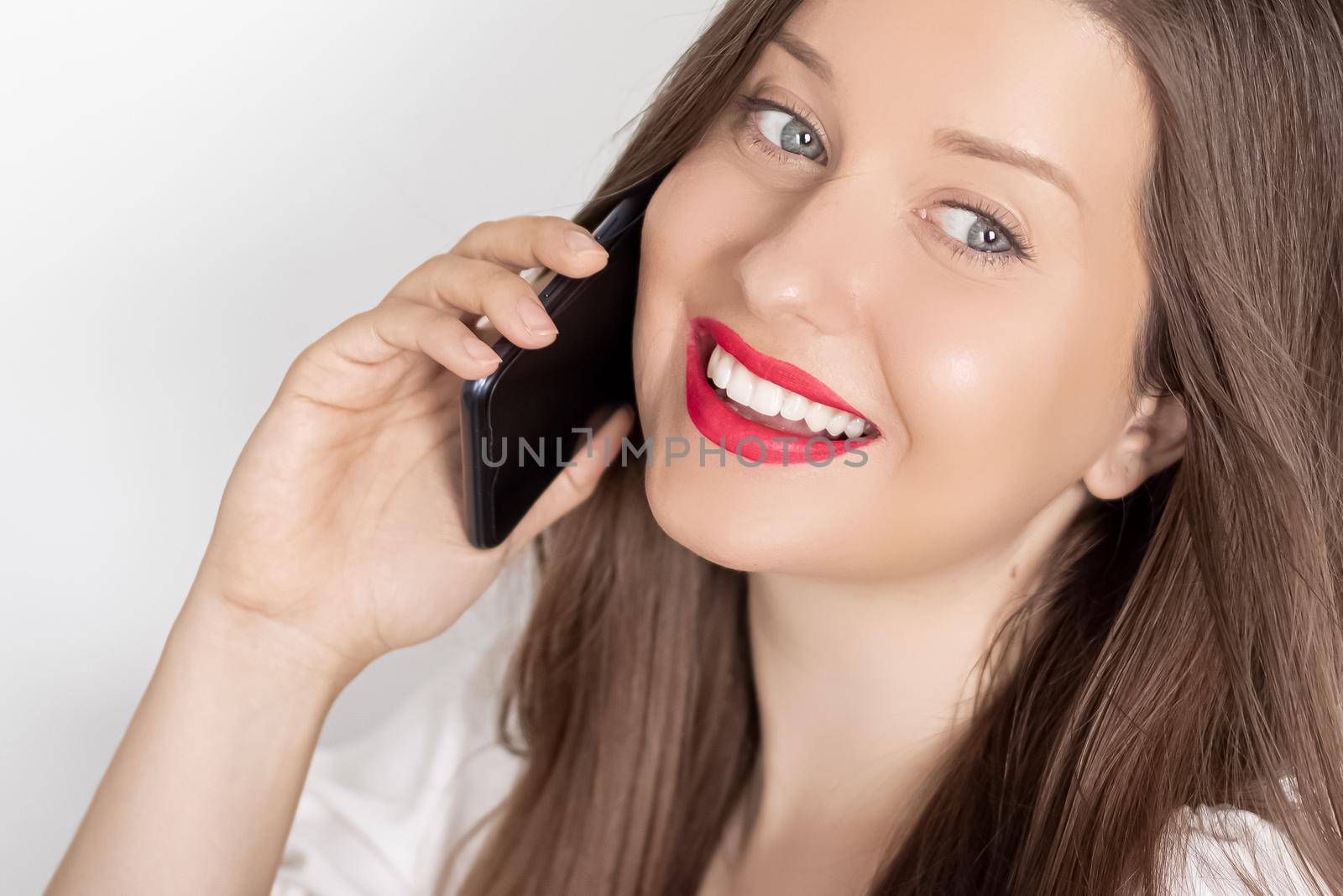 Happy smiling woman calling on smartphone, portrait on white background. People, technology and communication concept by Anneleven