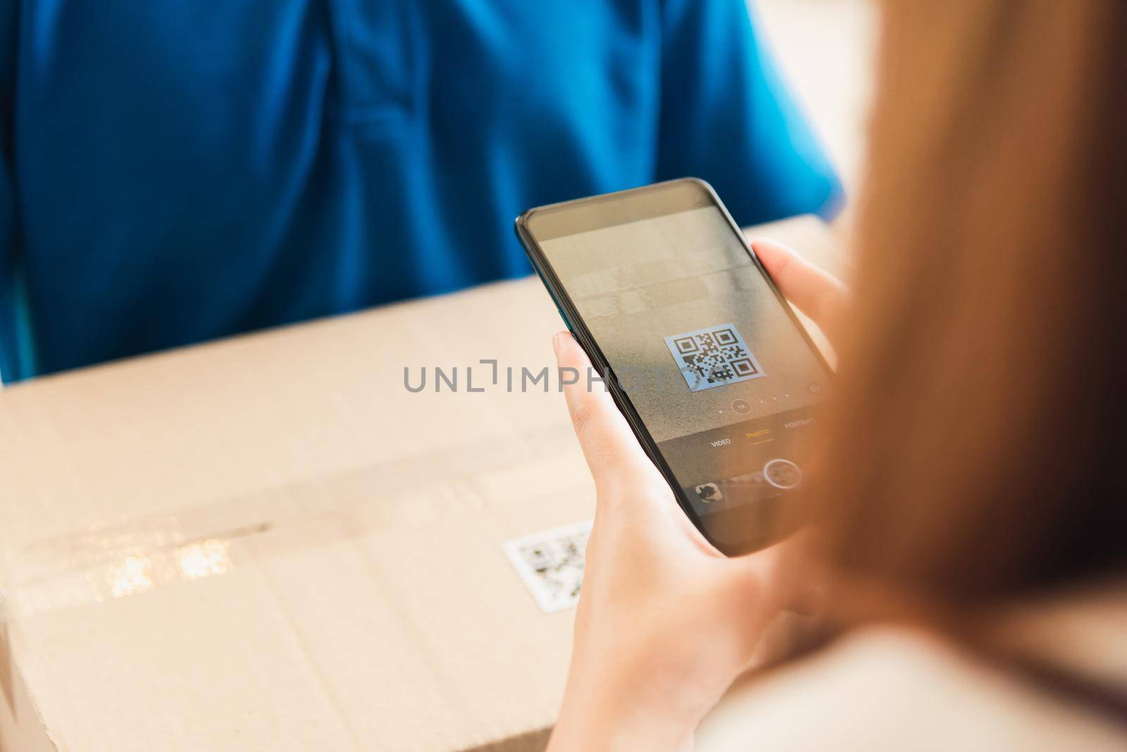 Asian customer young woman using mobile smartphone with QR code payment to receive parcel post box from delivery man, Hands of female scanning at door front house, Online shopping service concepts