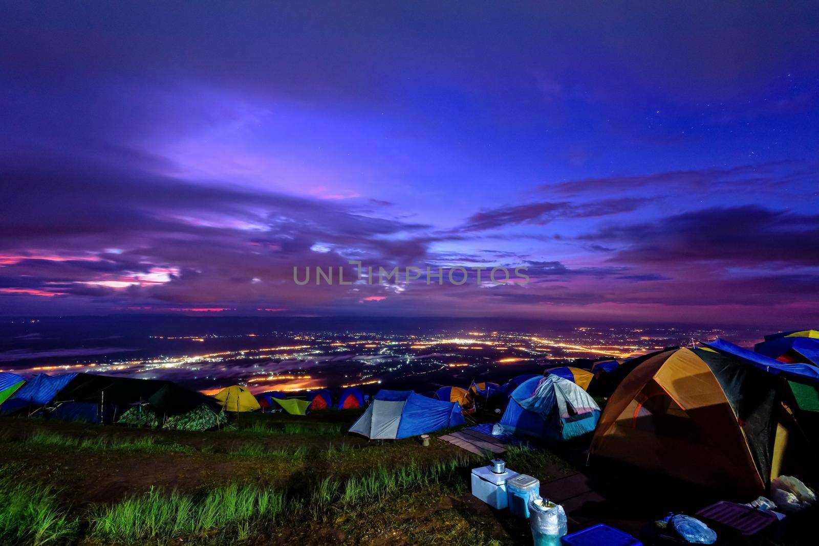 High view beautiful nature landscape of colorful sky during the sunrise, see the lights of the road and city from the campsite at Phu Thap Berk viewpoint, Phetchabun Province, Thailand