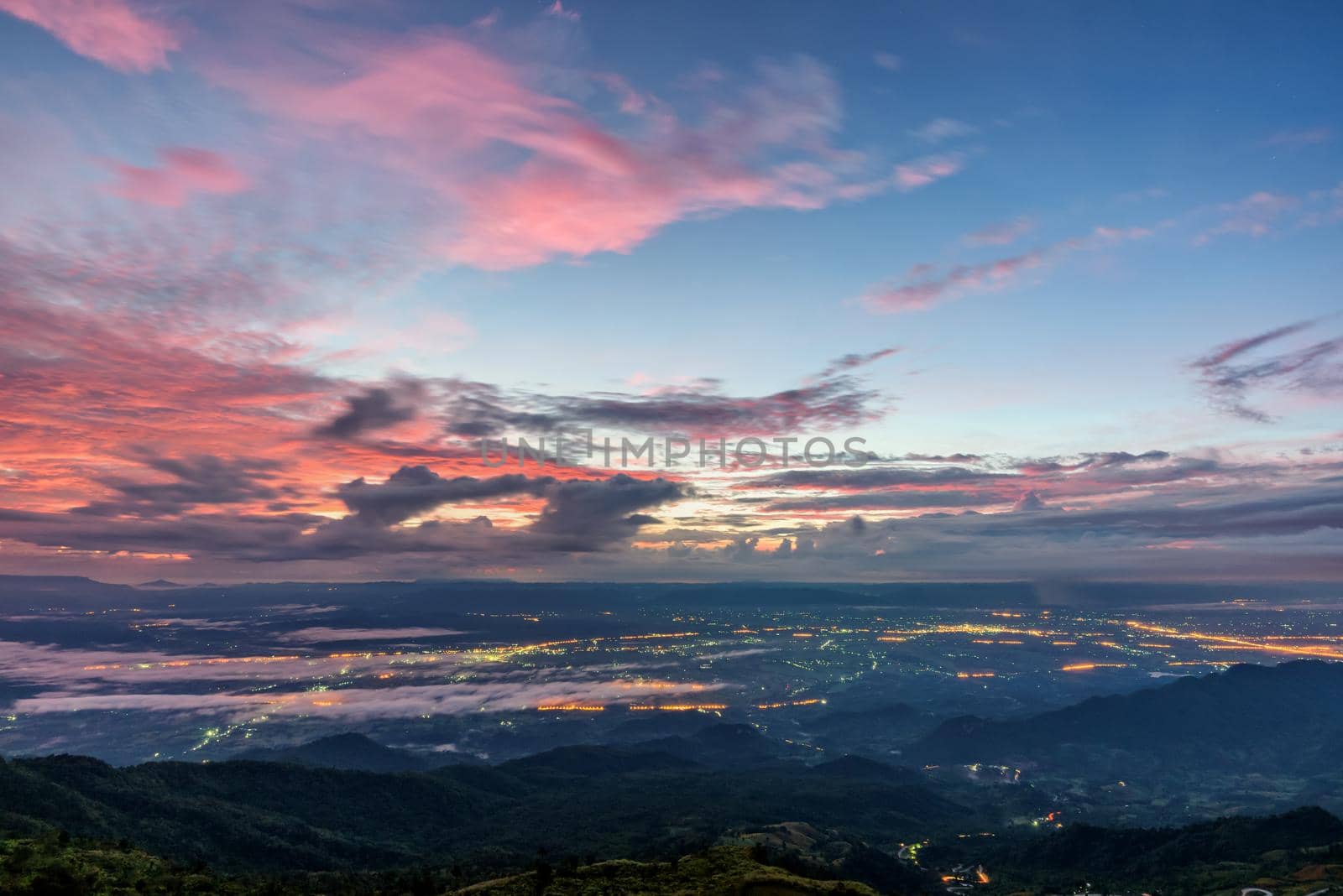 High view beautiful nature landscape of colorful sky during the sunrise see the lights of the road and city at Phu Thap Berk viewpoint famous tourist attractions of Phetchabun Province, Thailand