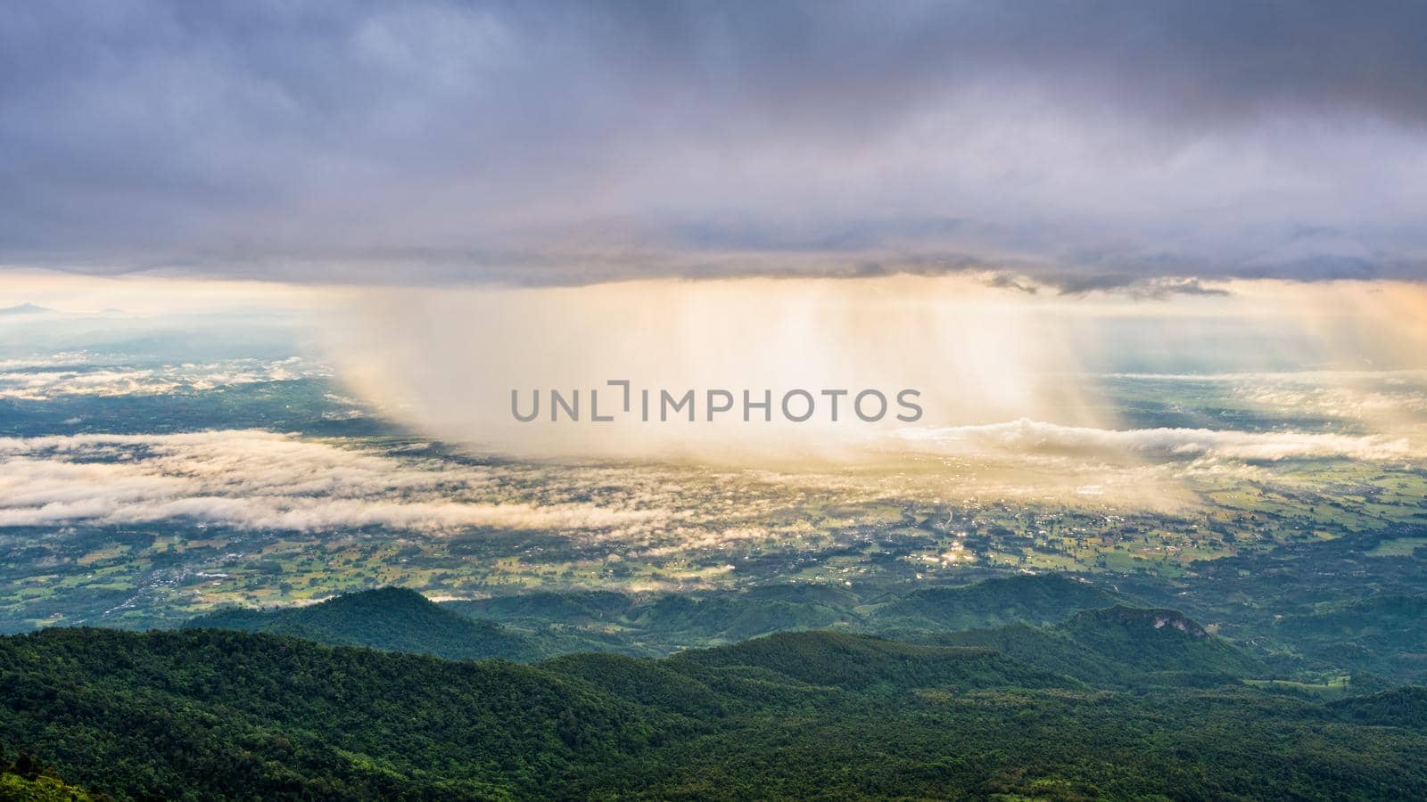 High view beautiful nature landscape of the mountain sky forest and the rain is falling sunlight shining through is golden at Phu Thap Berk viewpoint, Phetchabun, Thailand, 16:9 wide screen