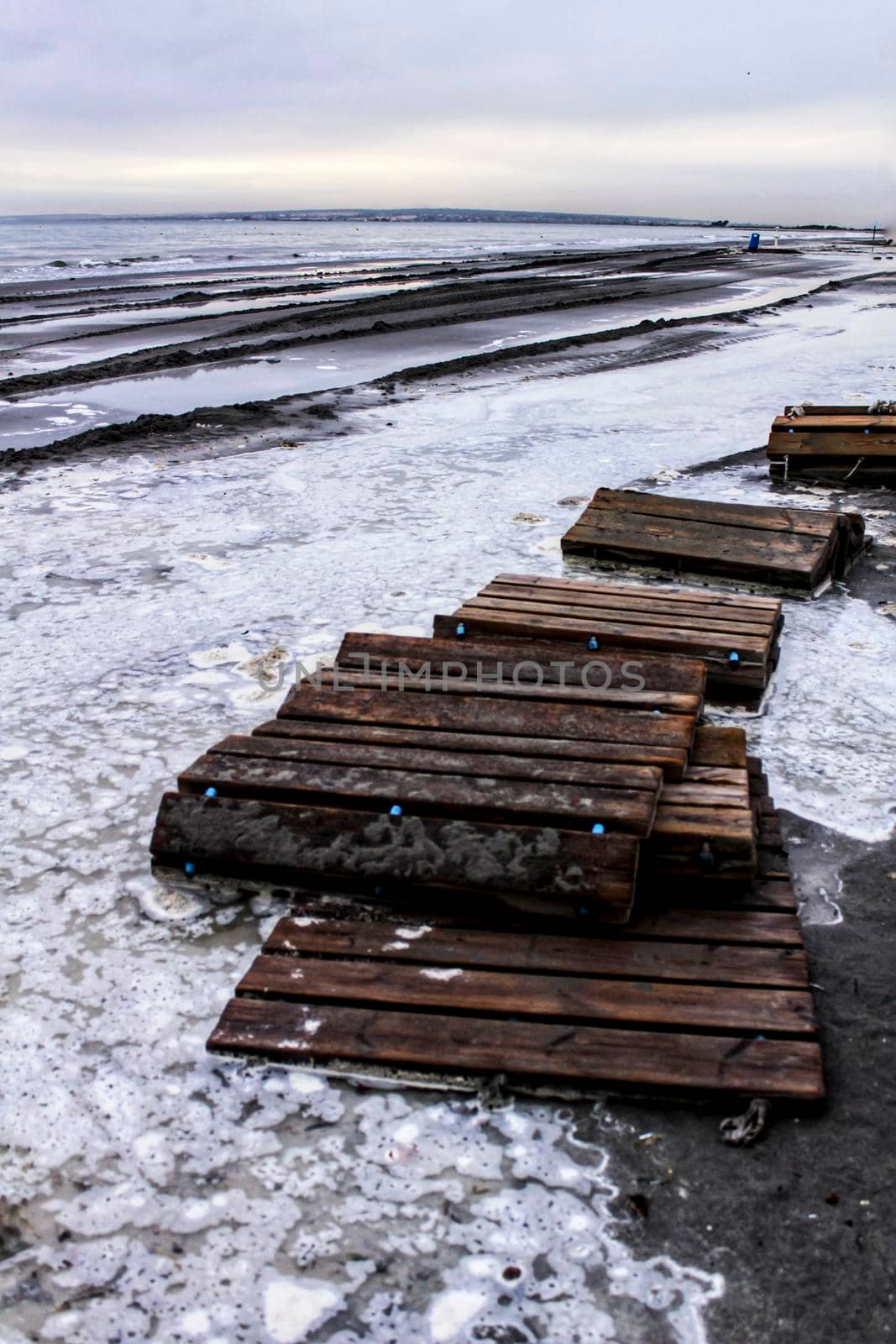 Beach flooded after the storm and broken wooden walkway in Alicante, Spain