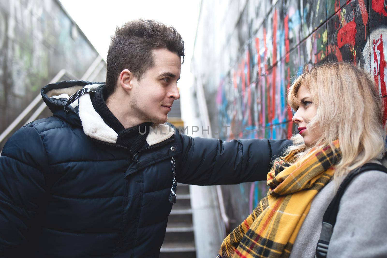 couple - girl and guy are flirting near the wall