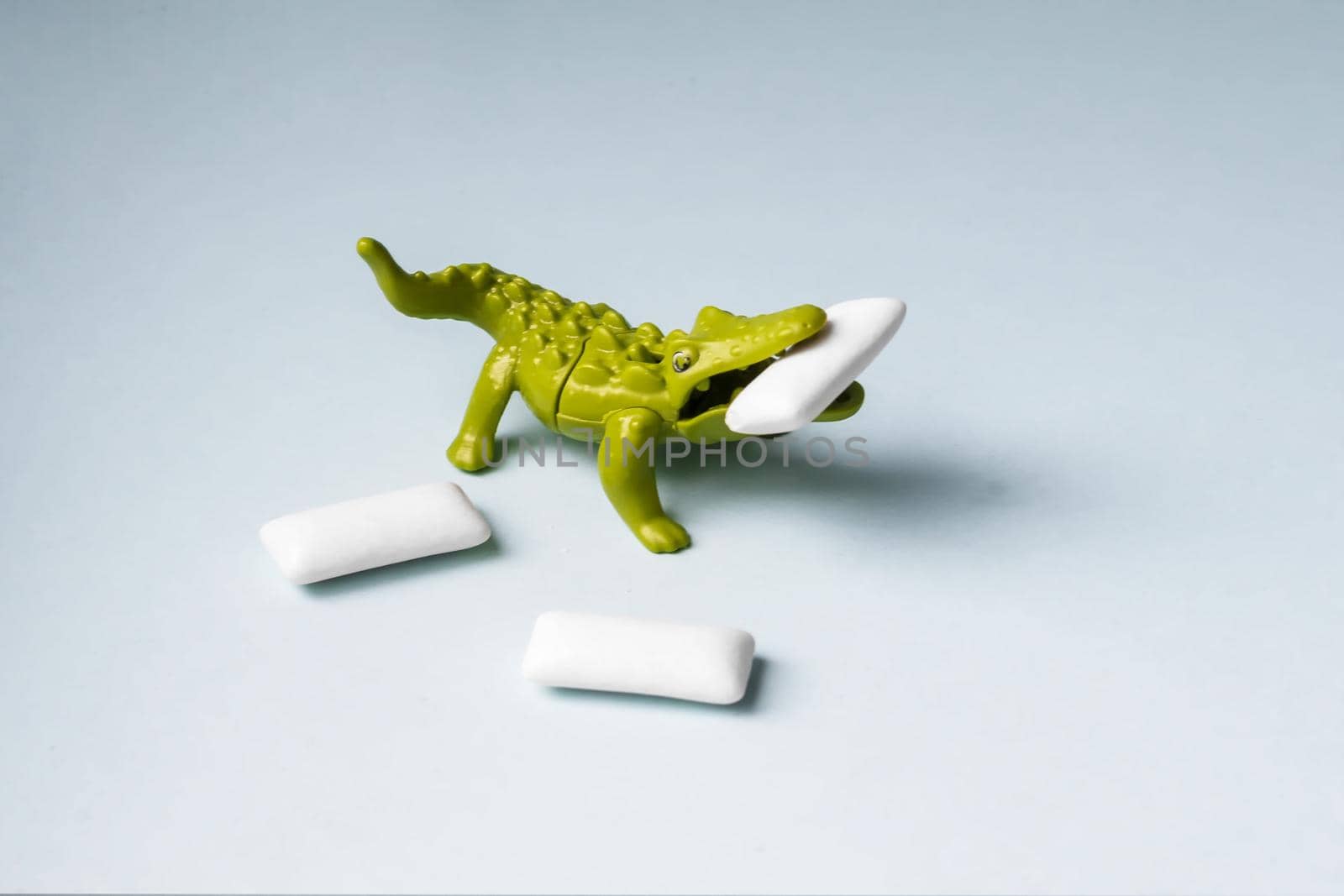 Green Toy crocodile eats chewing gum pads. by Essffes