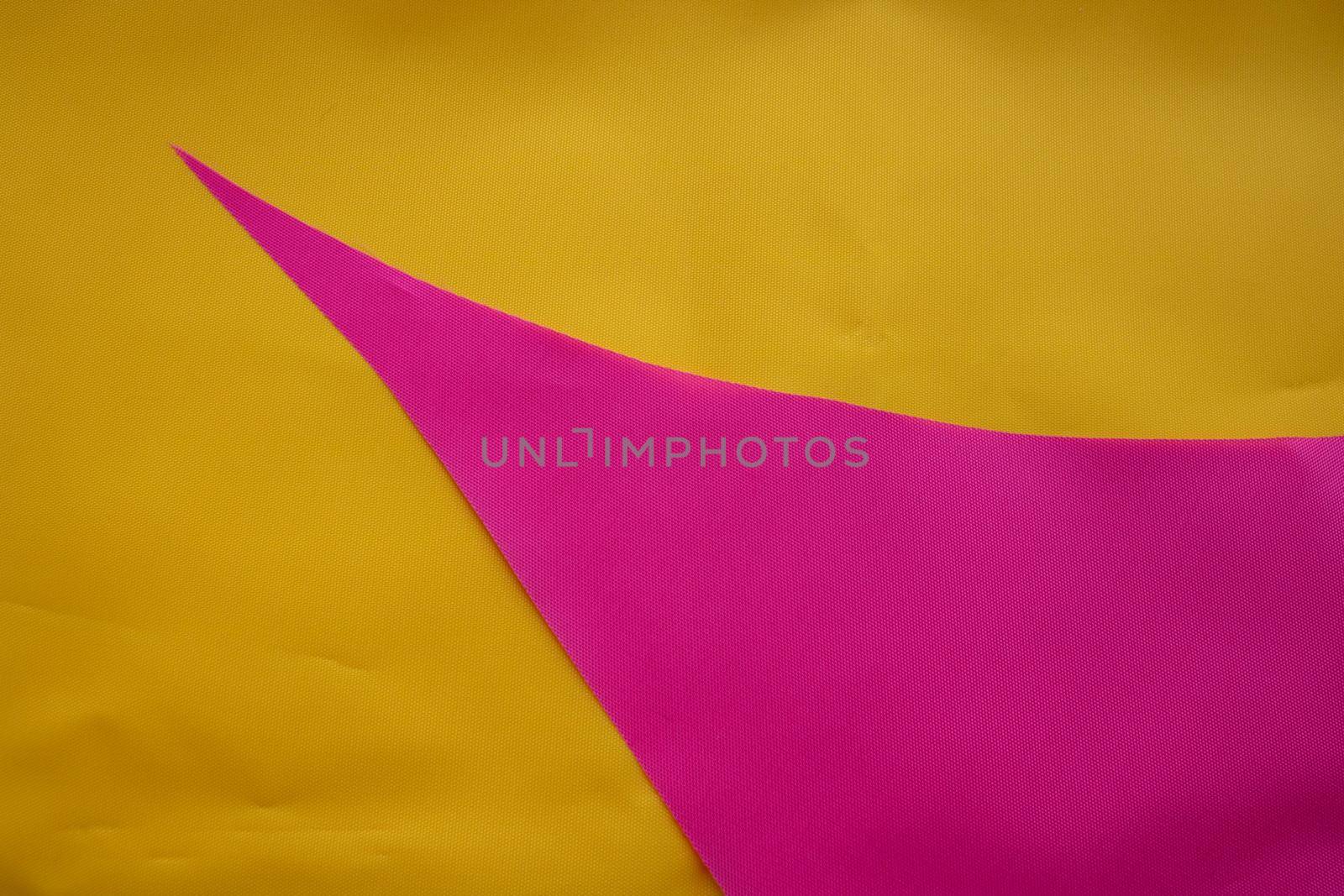 Pink pieces of fabric lie on the yellow fabric.