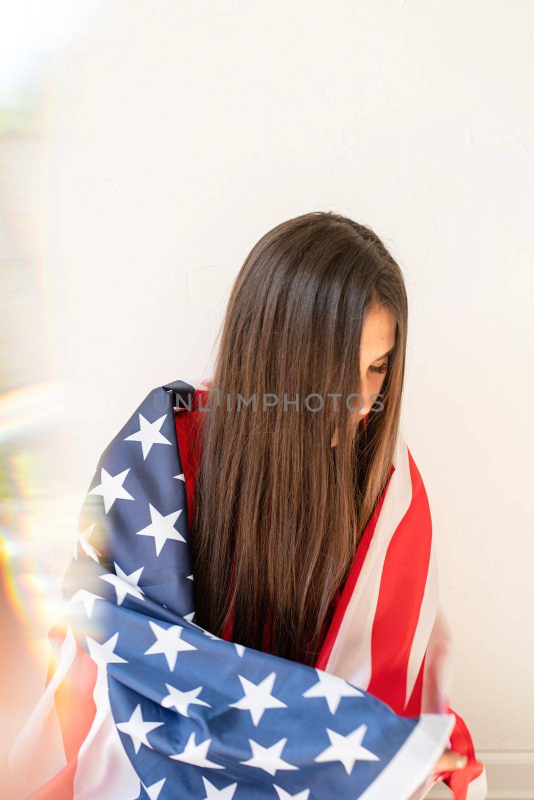 beautiful young woman with american flag on white background by Desperada