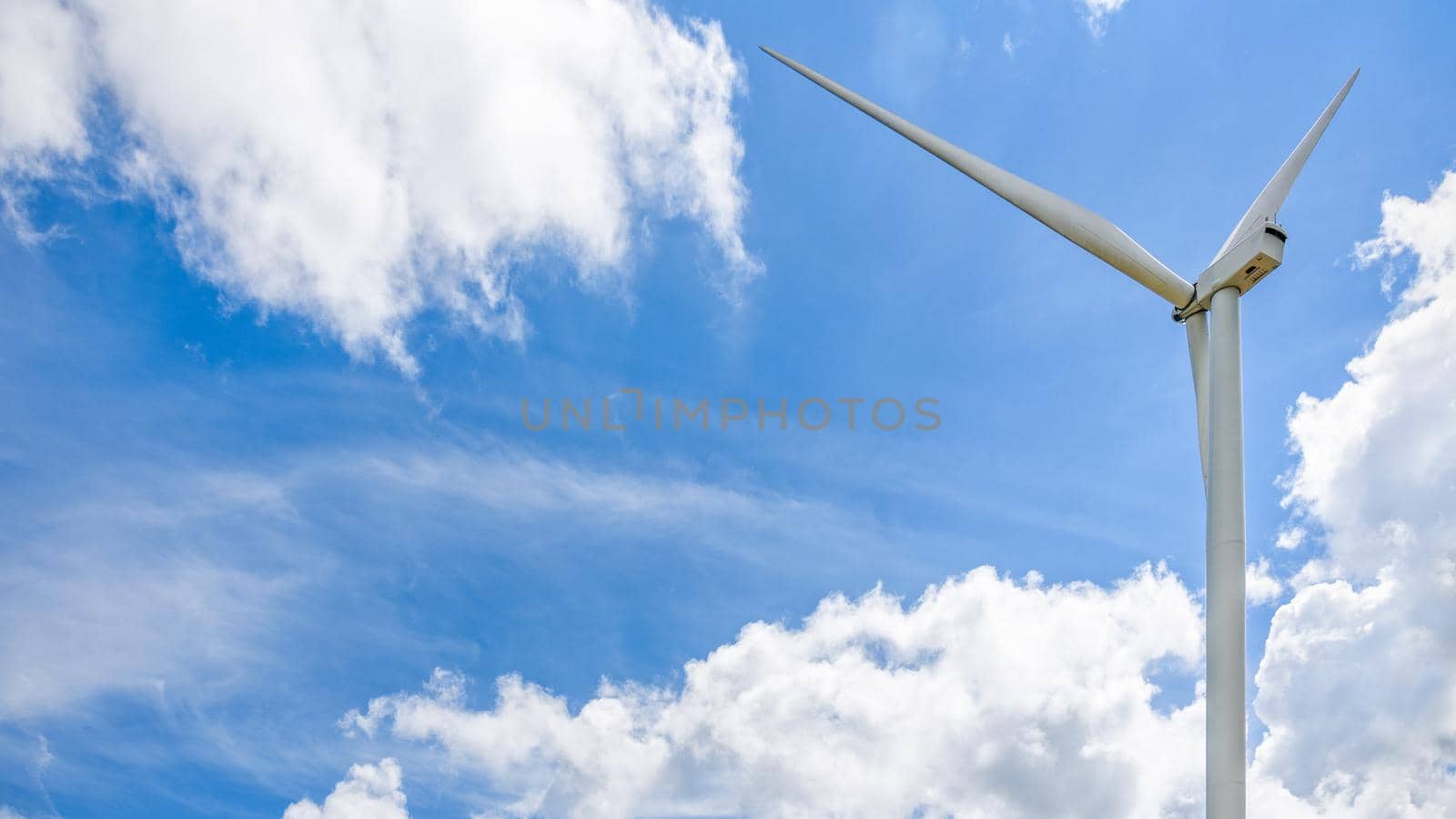Beautiful wind turbine on blue sky and white clouds background, Eco-friendly electric power source help reduce global warming, 16:9 wide screen