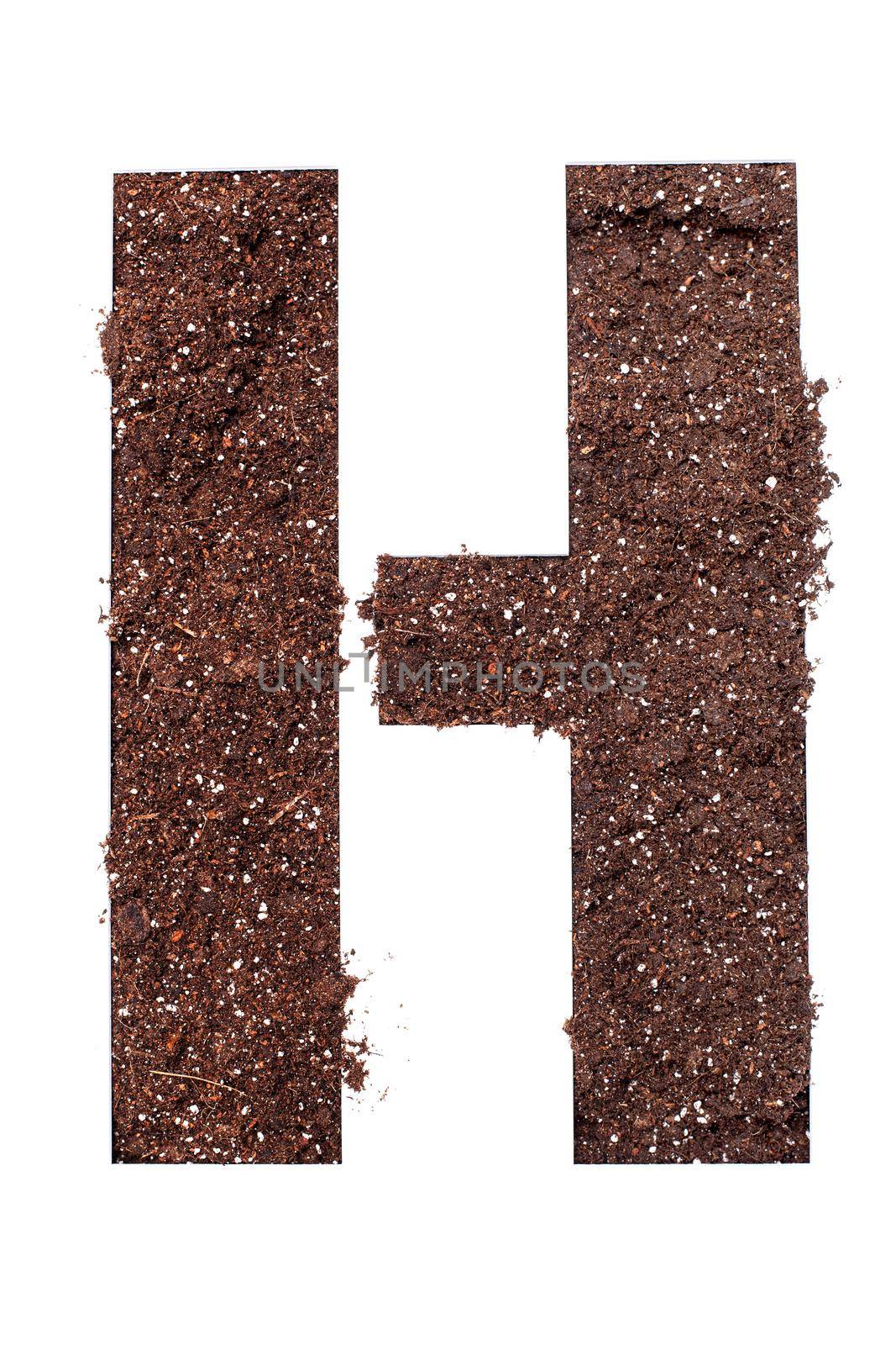 stencil letter H made above dirt on white surface
