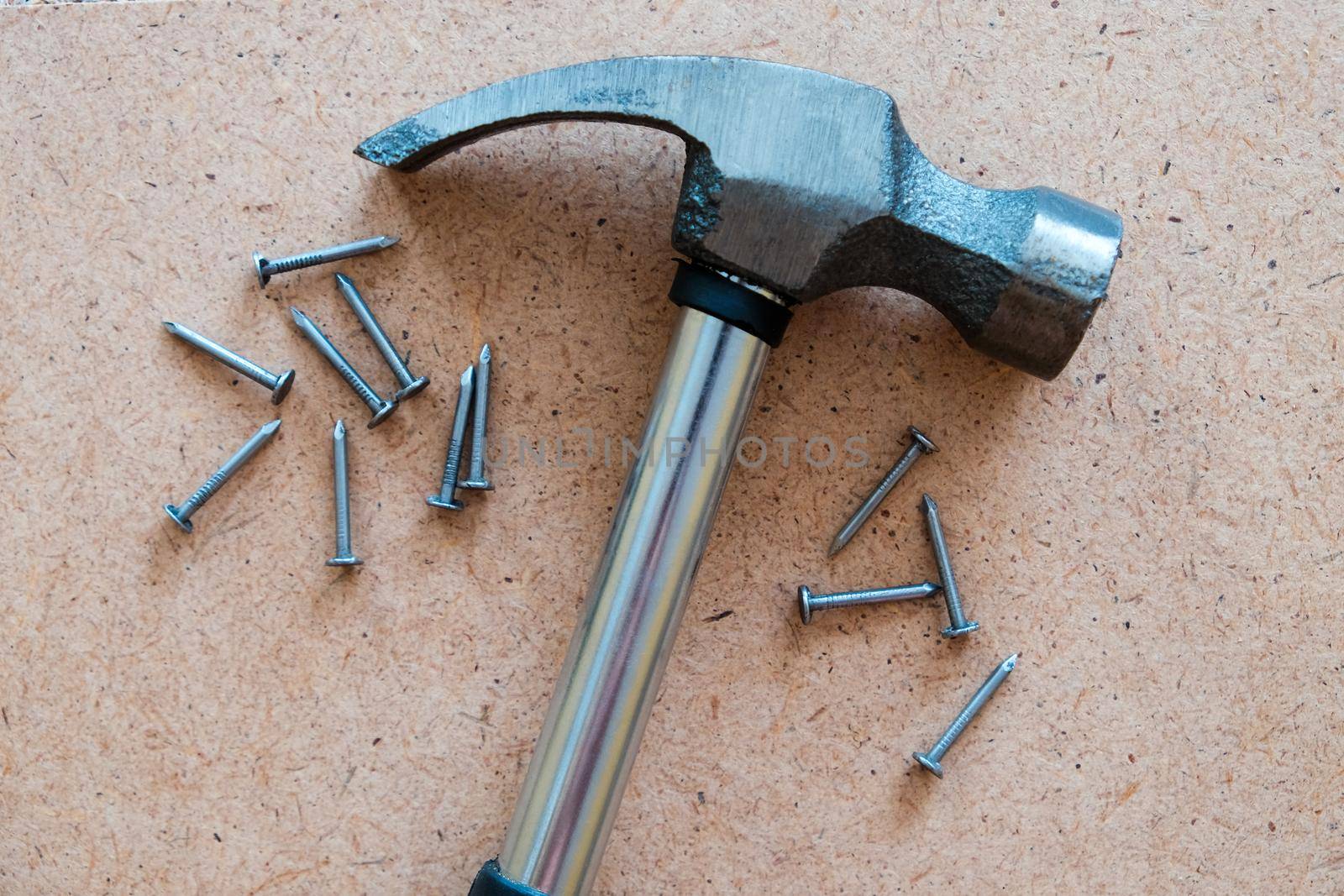 Iron hammer and nails on plywood. wood background.