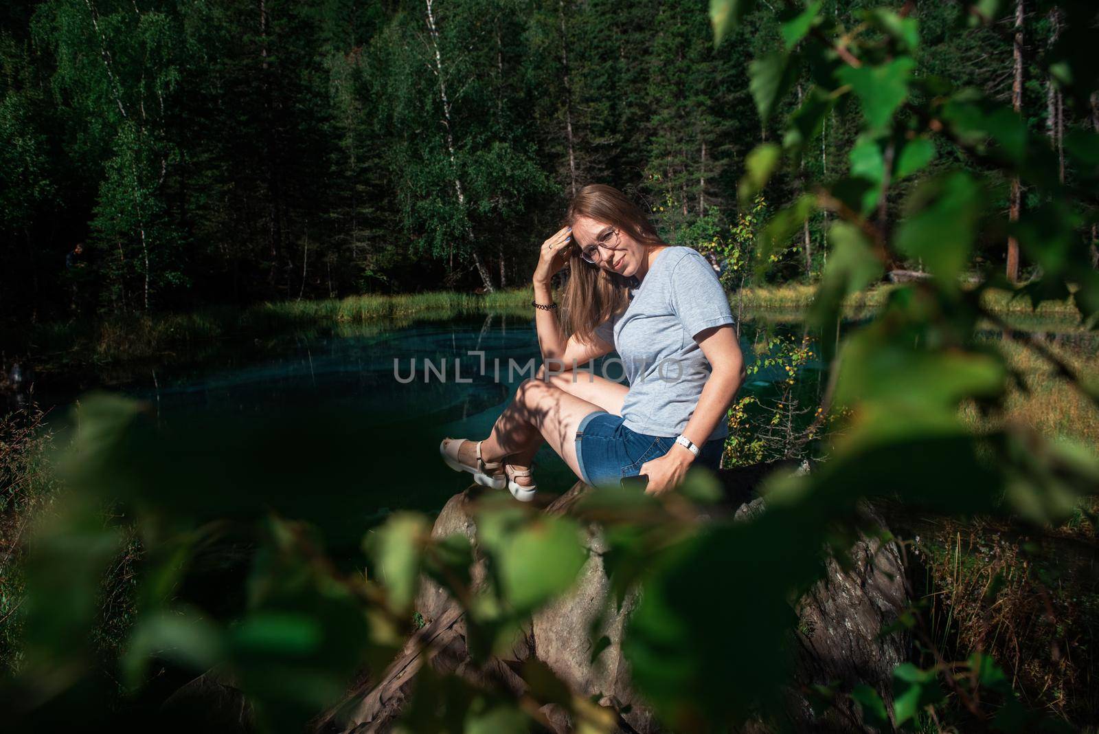 Woman resting at mountain lake in summer, Altai mountains