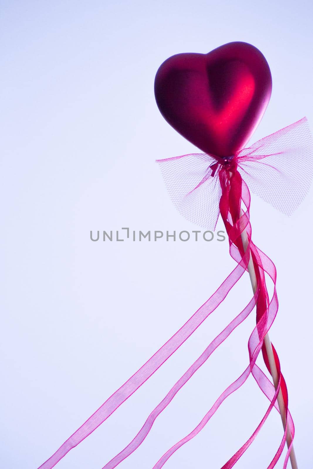Red heart attached to a stick with a bow hanging by GemaIbarra