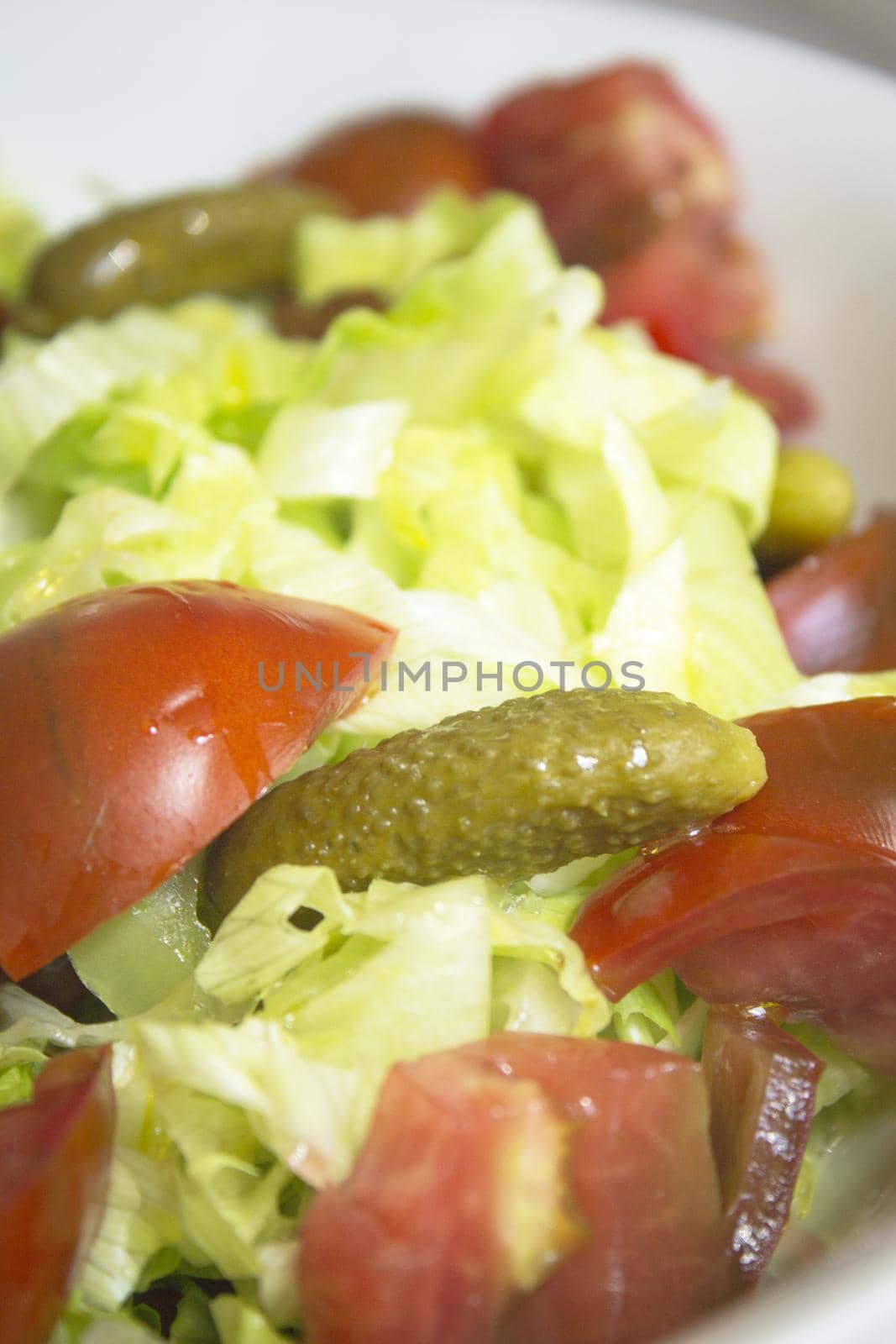 Lettuce salad with tomato and pickles. Raw food