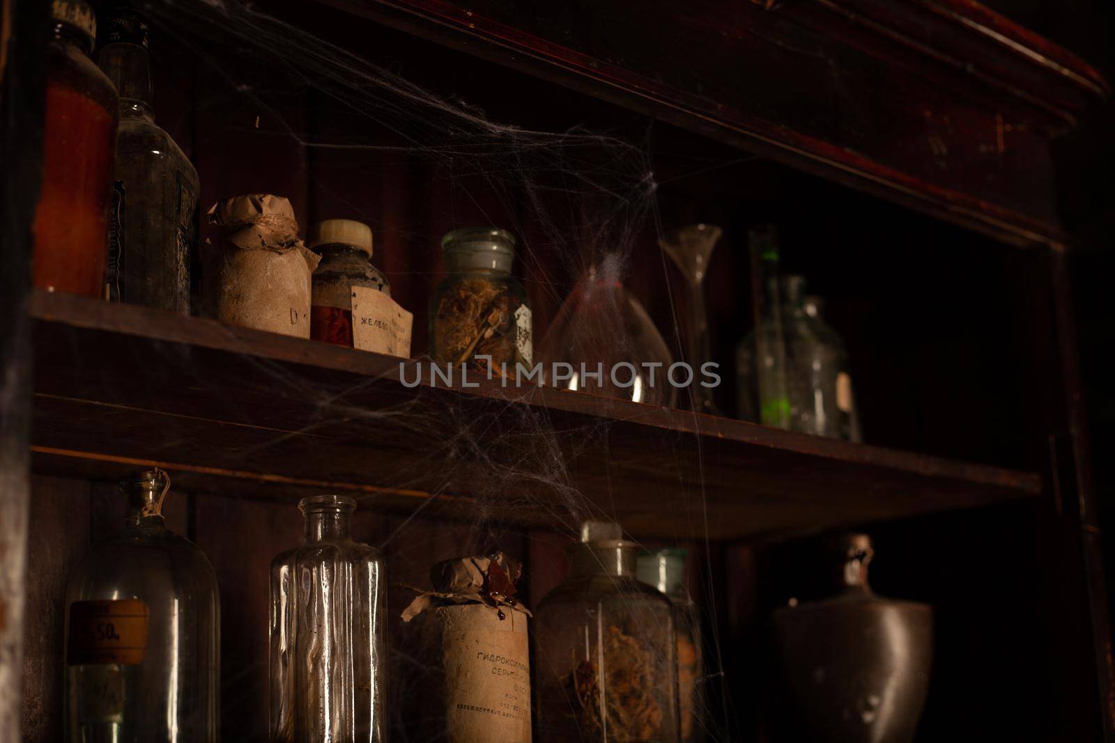Halloween background Shelves with alchemy tools Skull spiderweb bottle with poison candles Witcher workspace Scarry room