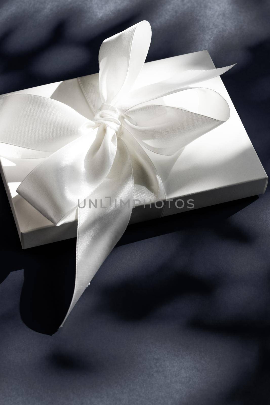 Anniversary celebration, shop sale promotion and luxe surprise concept - Luxury holiday white gift box with silk ribbon and bow on black background, luxe wedding or birthday present