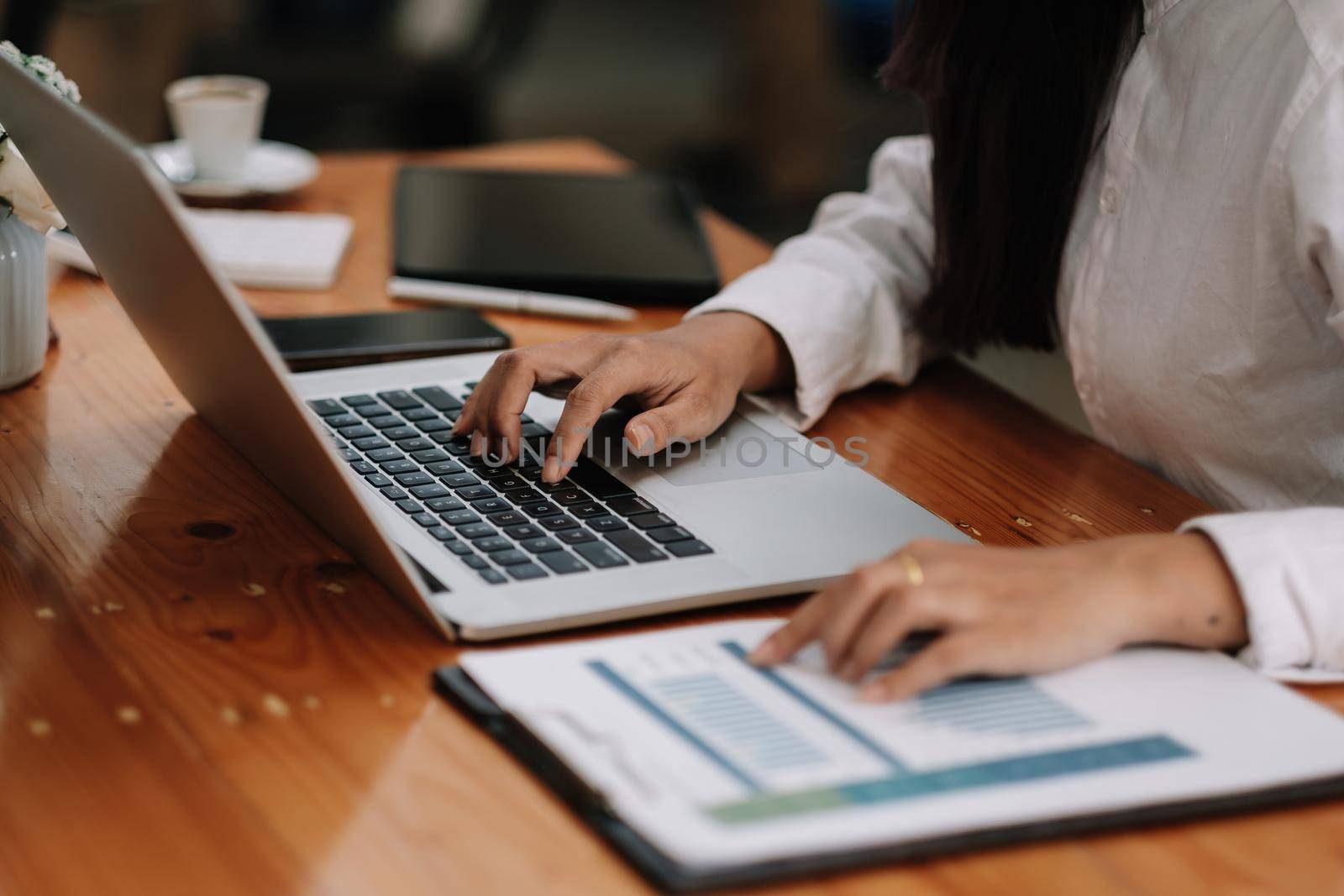 Business woman using laptop computer for do math finance on wooden desk in office and business working background, tax, accounting, statistics and analytic research concept