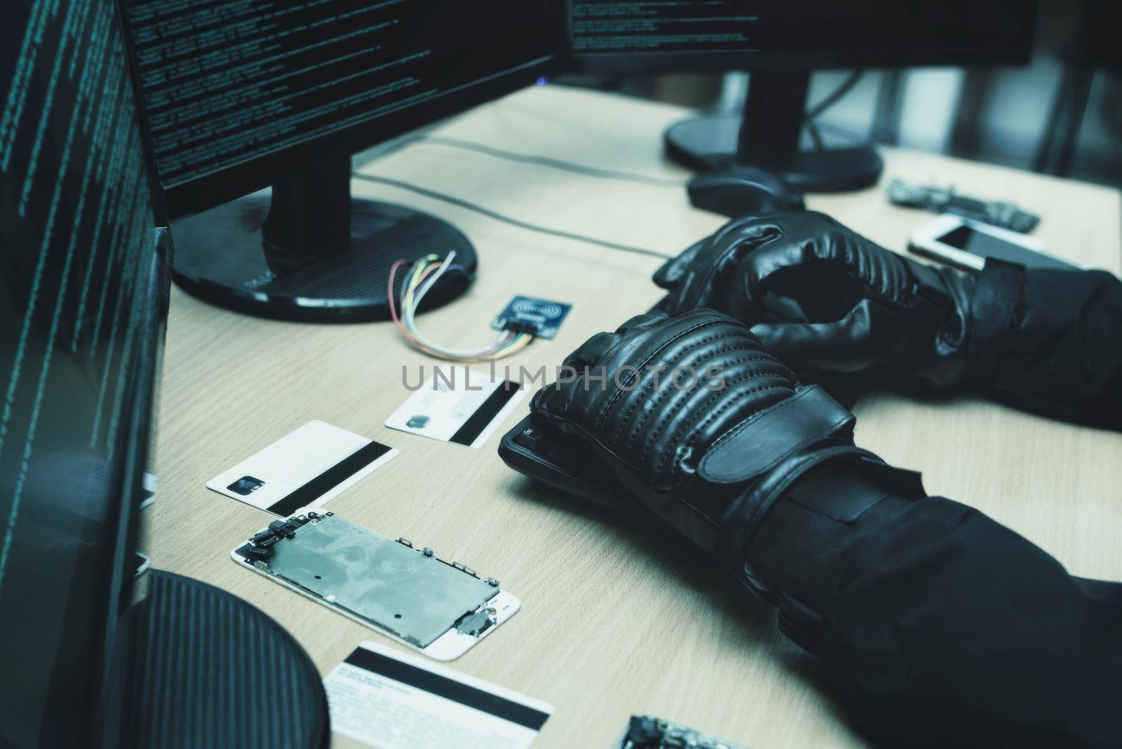 Shot from the Back to Hacker Breaking into Corporate Data Servers from His Underground Hideout. close view of hackers hands by Nickstock