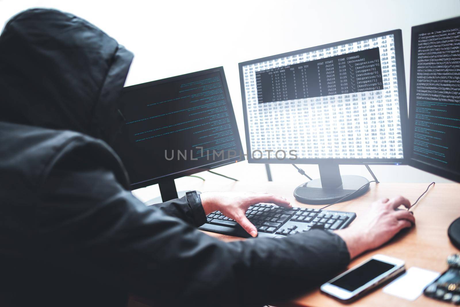 Picture of male hacker trying to steal information from system while looking at computer, isolated on white background by Nickstock