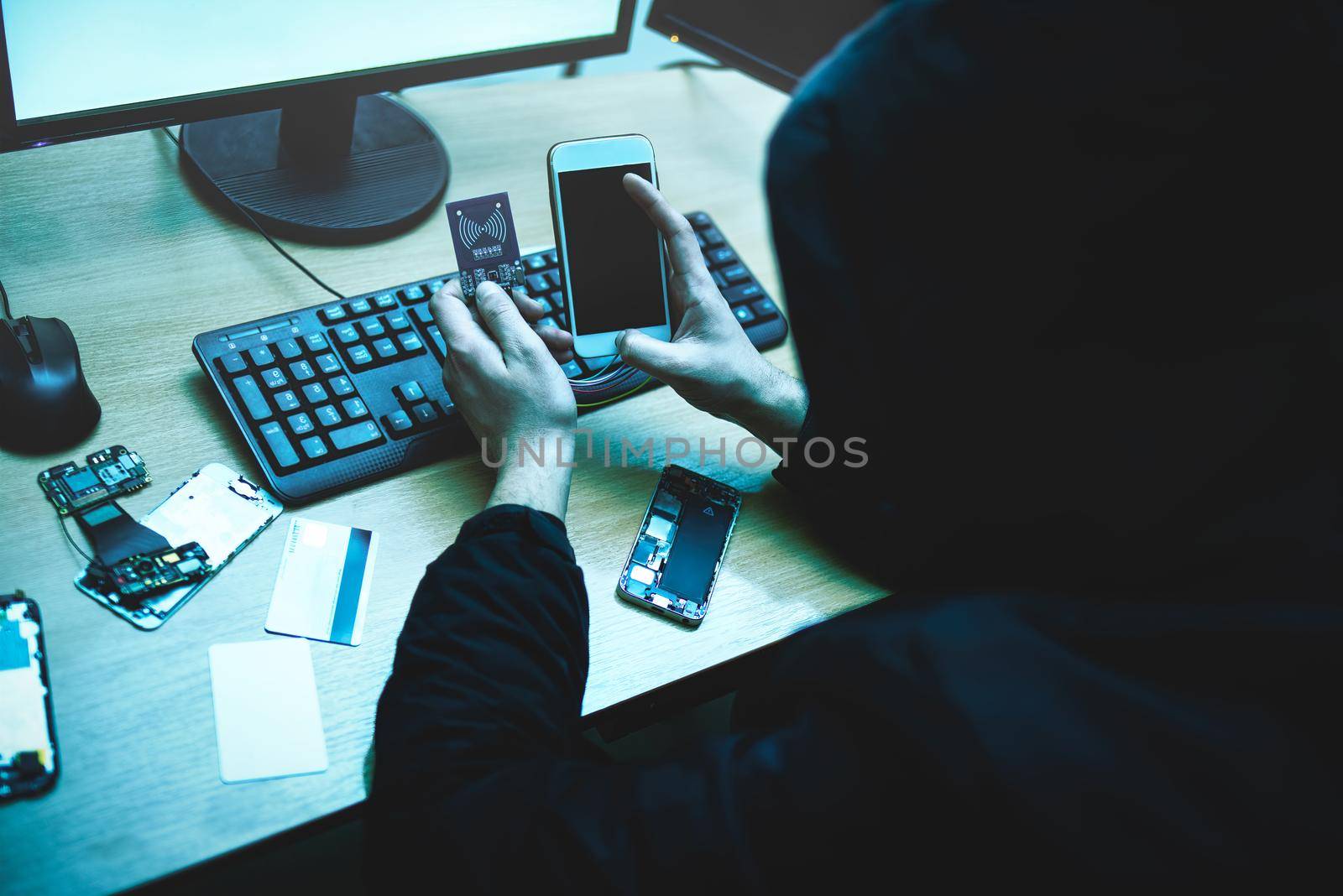 Male hacker is trying to access the phone. Security and protection of personal data. The concept of cyber crime and hacking electronic devices