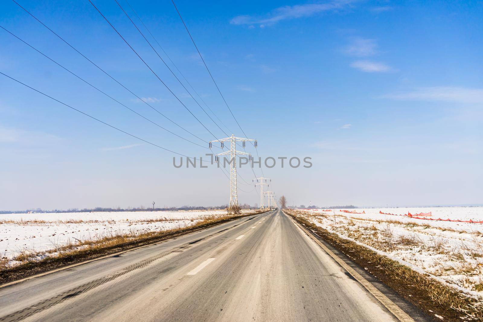 Winter season, view of cars and snowy street through windshield while driving in Bucharest, Romania, 2021.