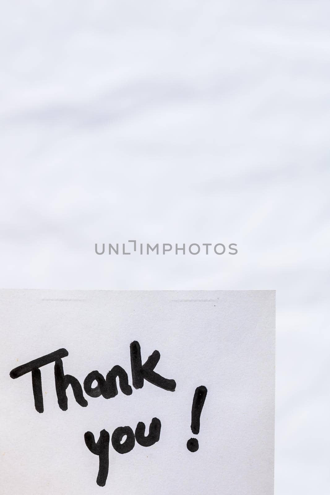 Thank you handwriting text close up isolated on white paper with copy space. Writing text on memo post reminder by vladispas