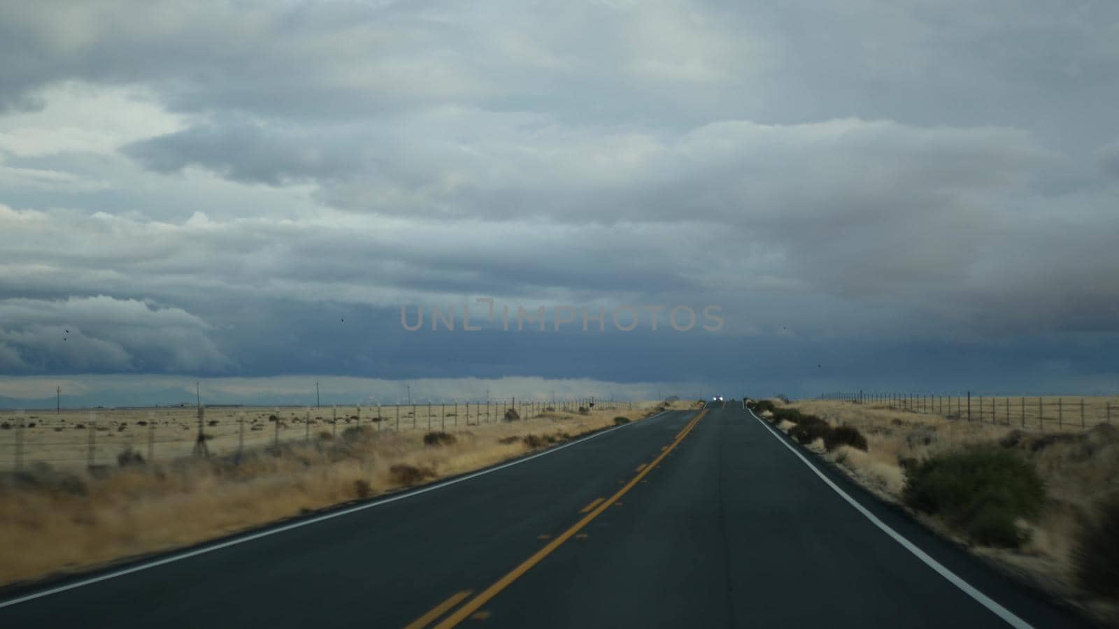 Driving auto, road trip in California, USA, view from car. Hitchhiking traveling in United States. Highway, mountains and cloudy dramatic sky before rain storm. American scenic byway. Passenger POV by DogoraSun
