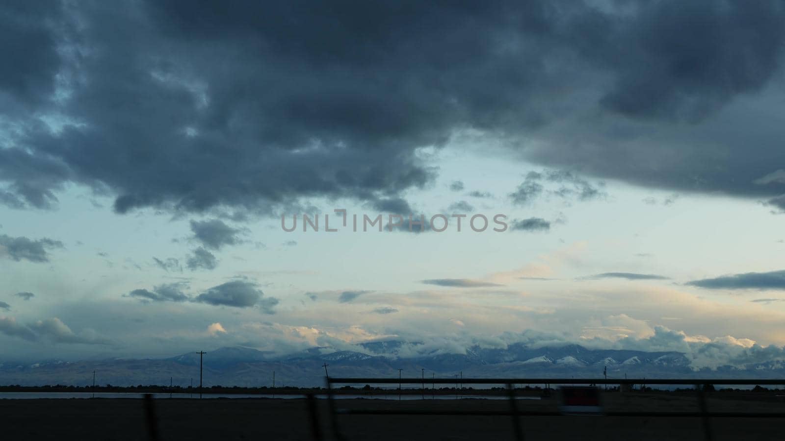 Driving auto, road trip in California, USA, view from car. Hitchhiking traveling in United States. Highway, mountains and cloudy dramatic sky before rain storm. American scenic byway. Passenger POV by DogoraSun