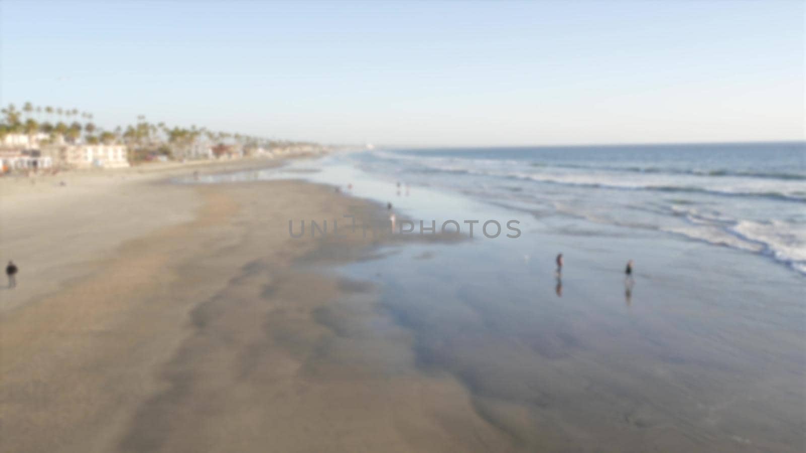 Pacific ocean coast from pier. Sea waves. Beachfront vacations. California USA. Palm tree and houses by DogoraSun