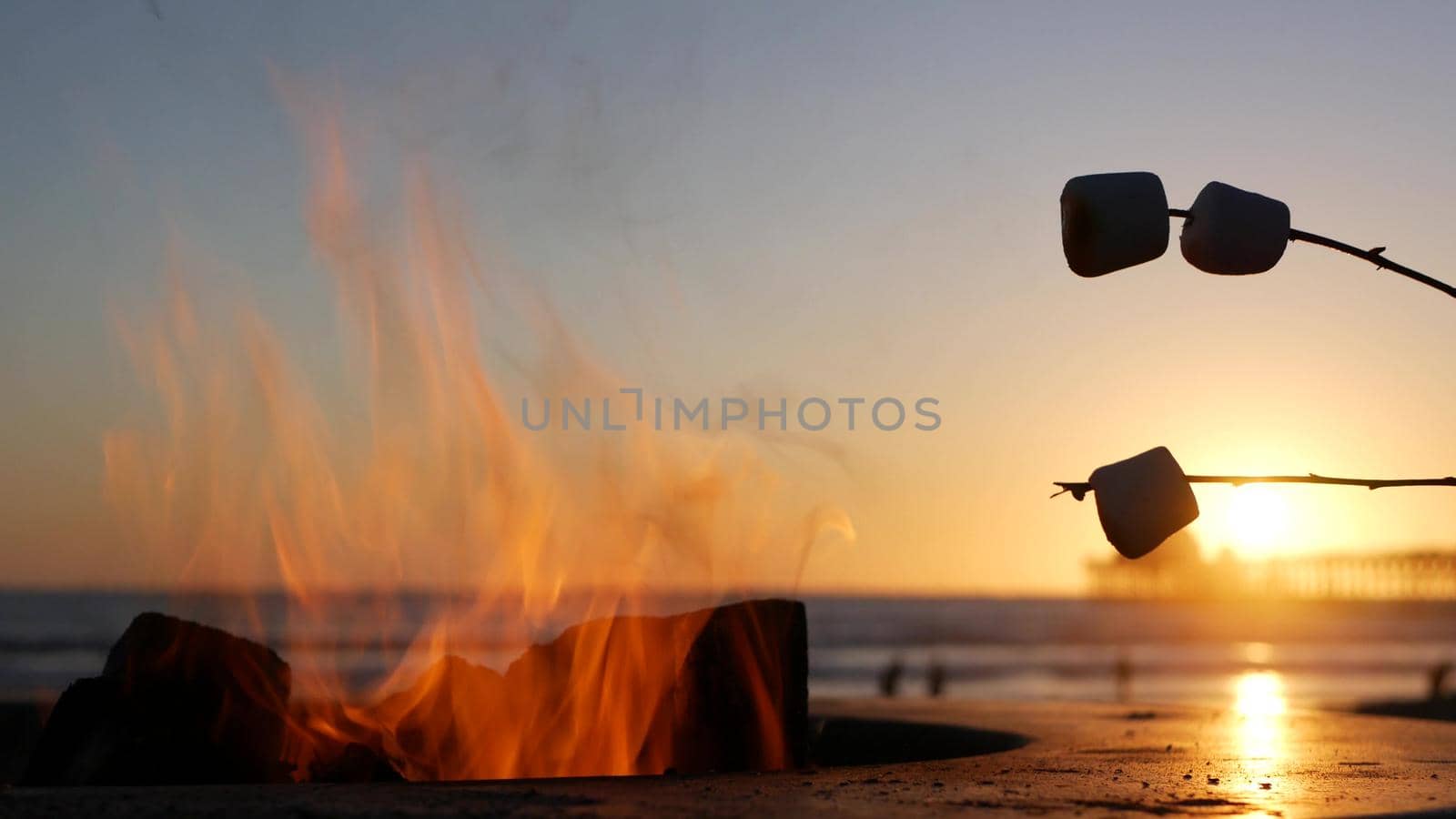 Campfire pit in California USA. Camp fire on ocean sea beach, roasting toast marshmallow on bonfire. by DogoraSun