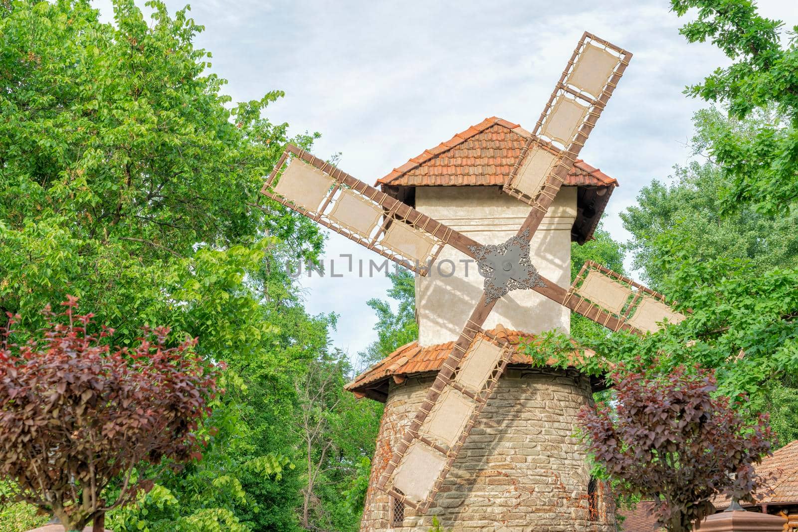 traditional windmill with blue sky and green leaves. retro. close-up. High quality photo
