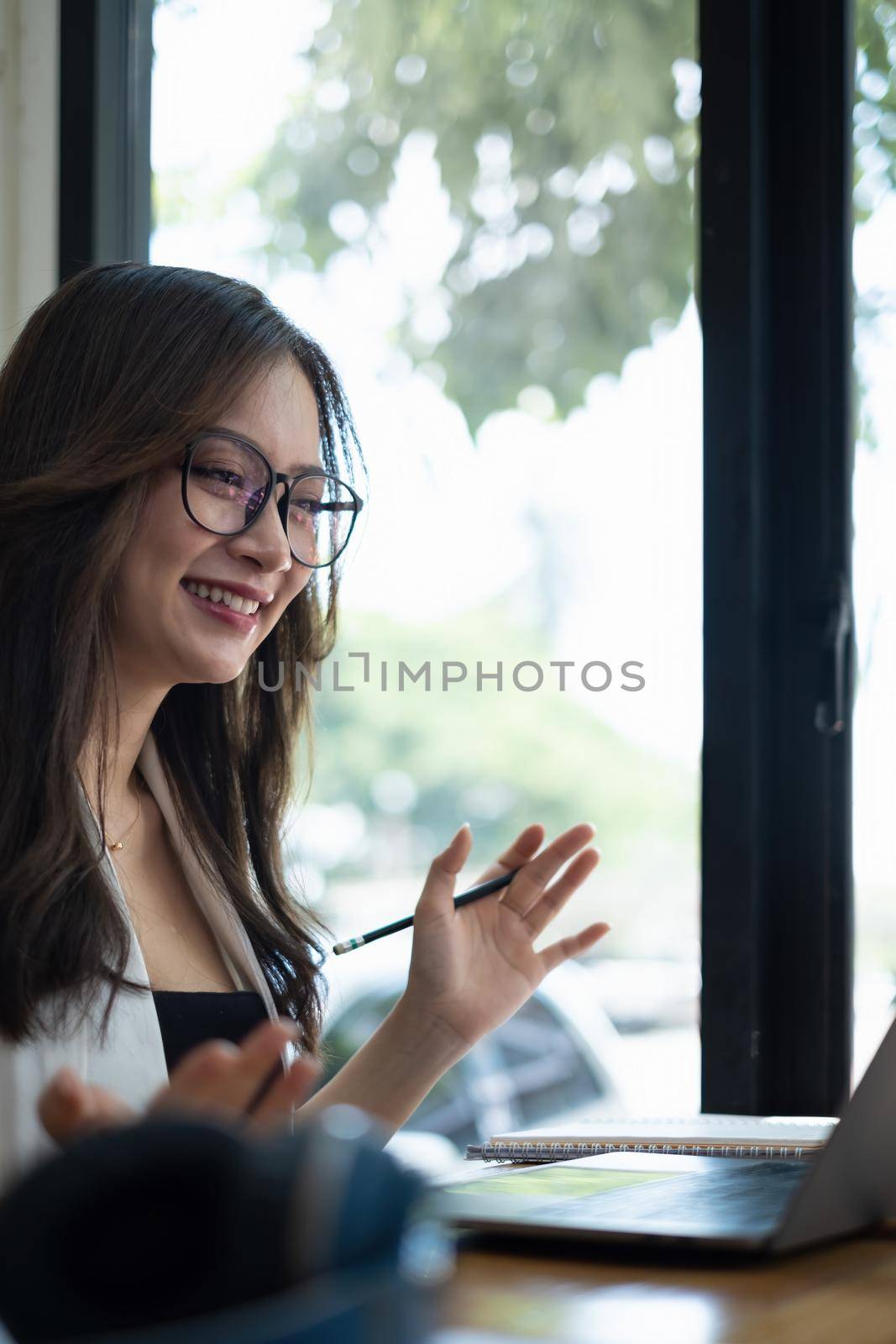 Business woman try to explain about his work to business team by video call at home office