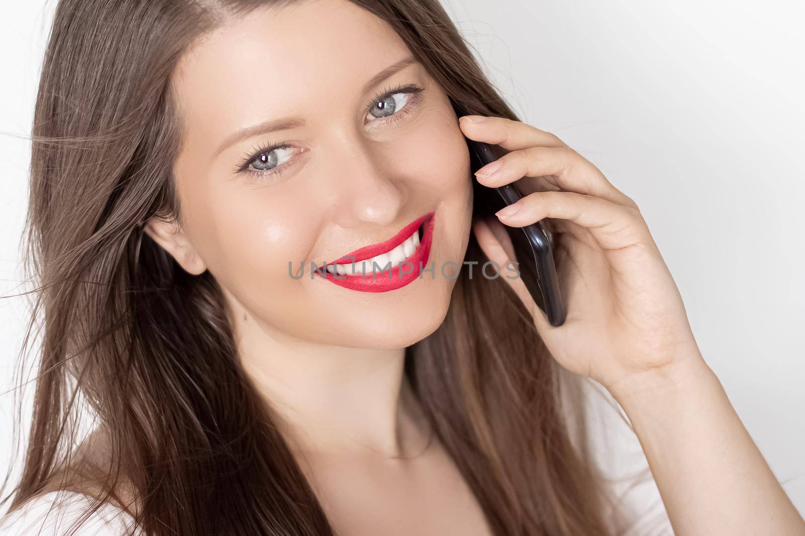 Happy smiling woman calling on smartphone, portrait on white background. People, technology and communication concept.