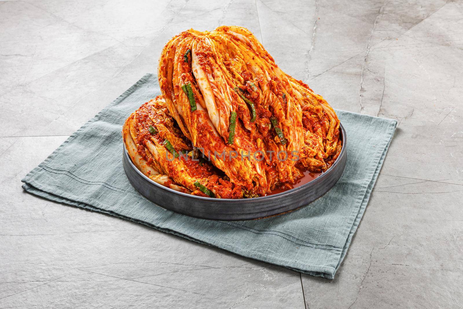 Kimchi in dish set on gray background by uphotopia