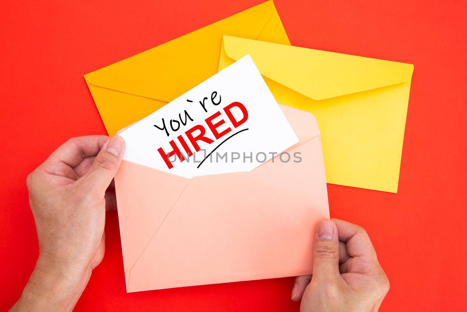 You're Hired Concepts - Hand holding a envelope and white post card