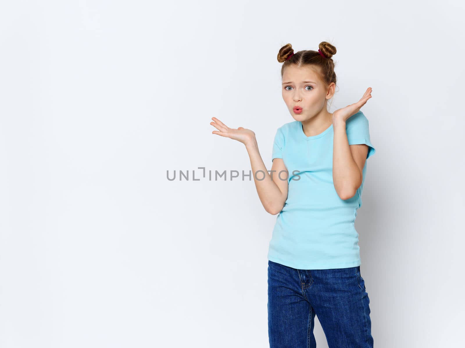 Emotional girl with pigtails on her head gestures with her hands lifestyle style clothes